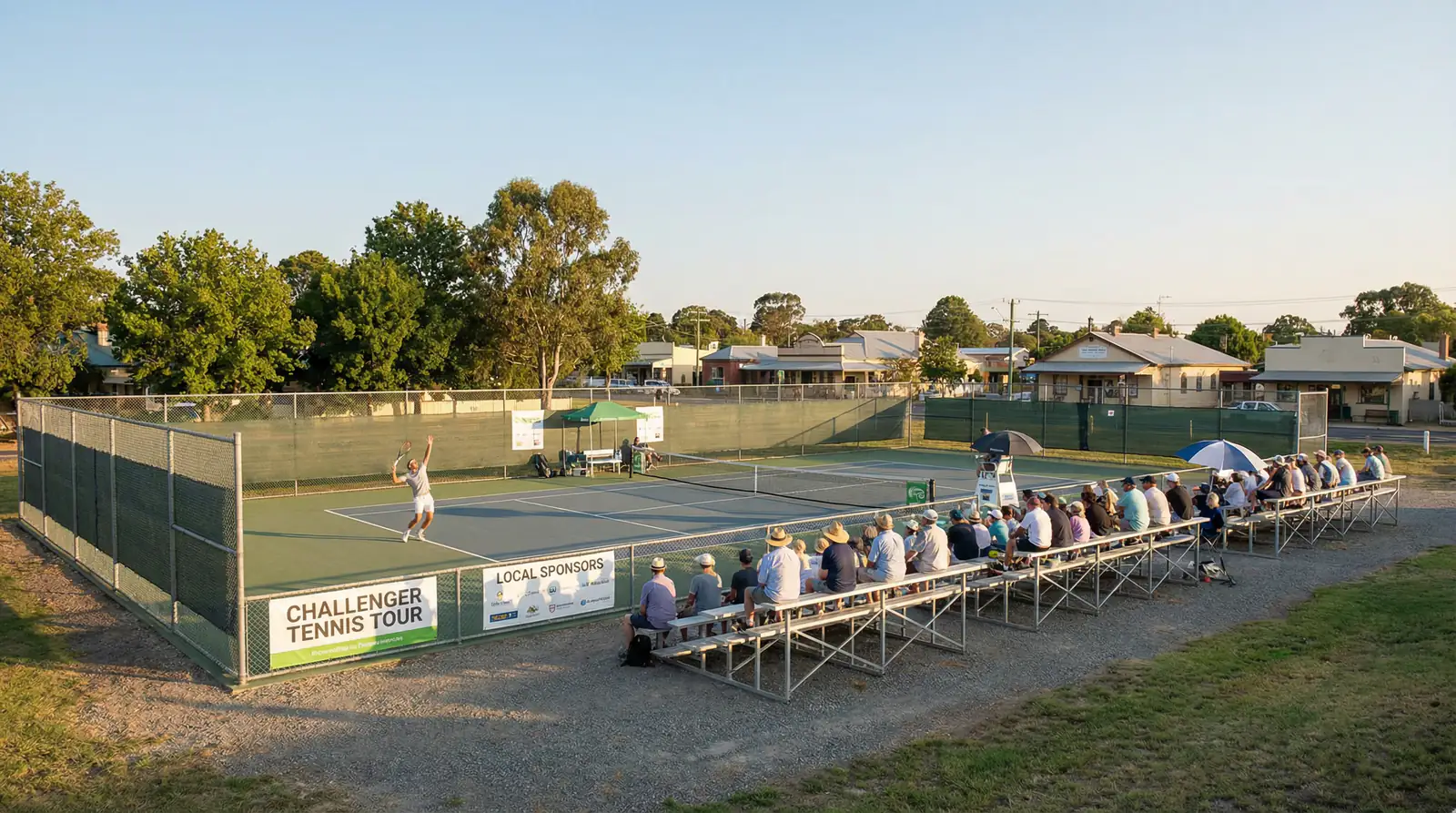Pista de tenis de torneo Challenger con gradas pequeñas y jugador al fondo