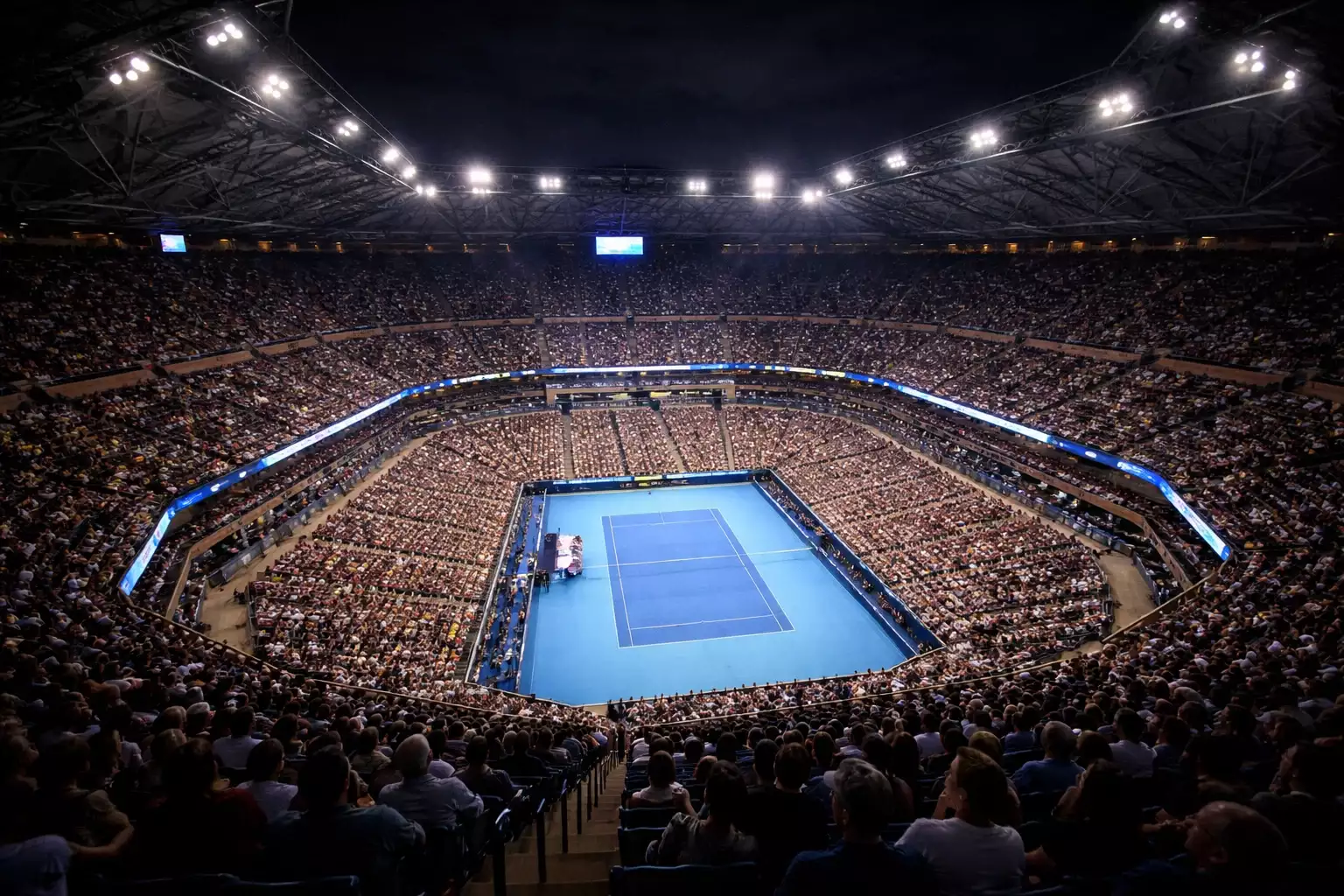 Estadio Arthur Ashe del US Open iluminado durante sesión nocturna