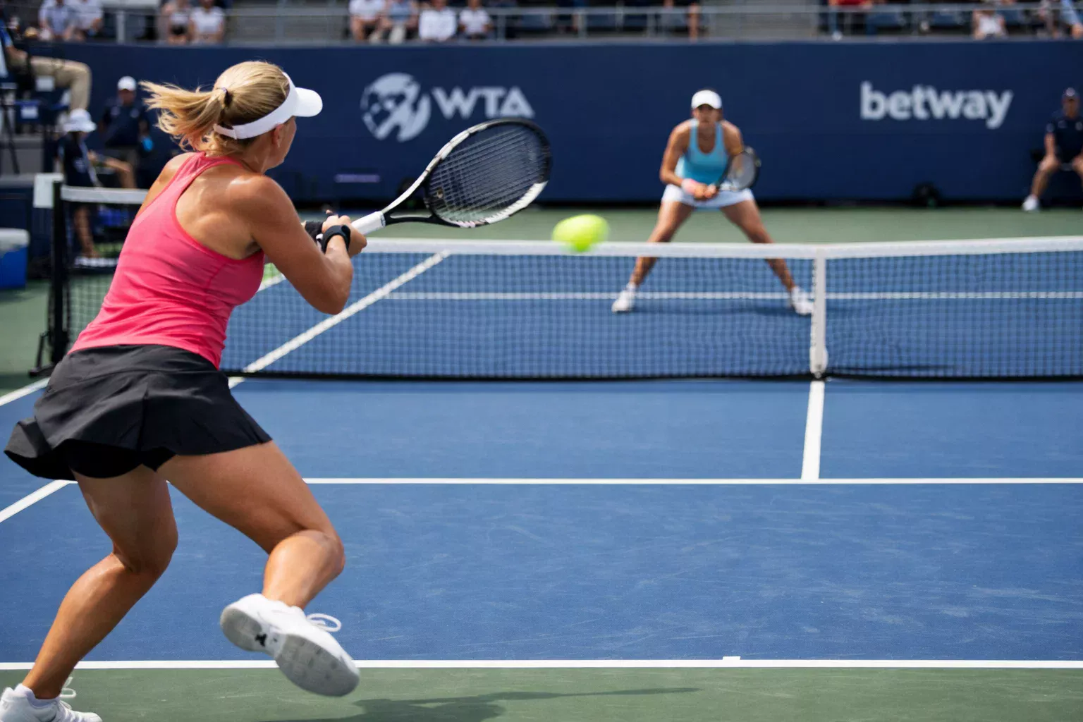 Partido de tenis femenino WTA mostrando intercambio de golpes desde fondo